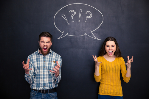 Crazy couple screaming over chalkboard background